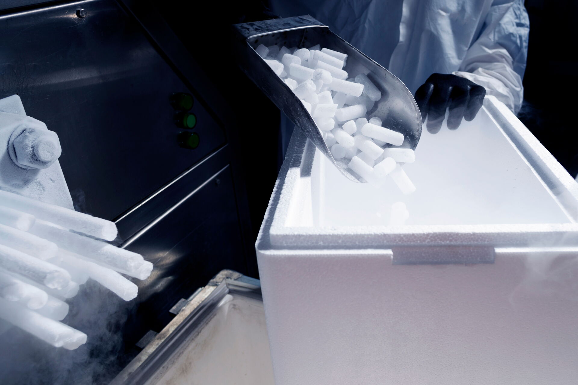 Mitarbeiter befüllt Isolierbox mit Trockeneis-Pellets bei Trockeneis Bavaria GmbH in Reichertshofen – Qualitätsverpackung.